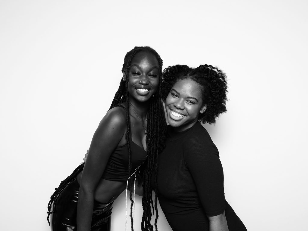 Two black women posing for a glamorous black and white photo.