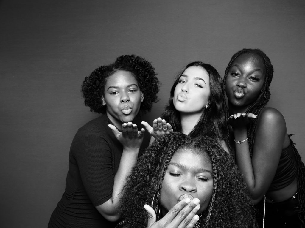 A black and white photo of women kissing taken in a glam booth.