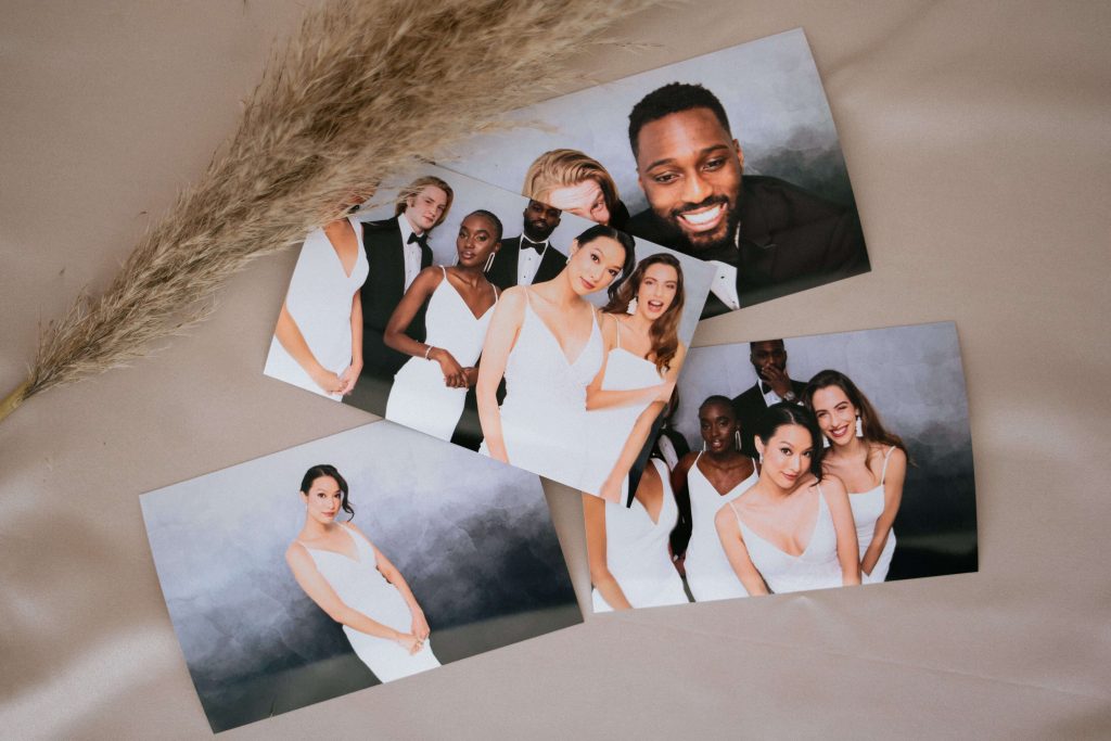 A group of brides and grooms pose for a photo in a wedding photo booth.